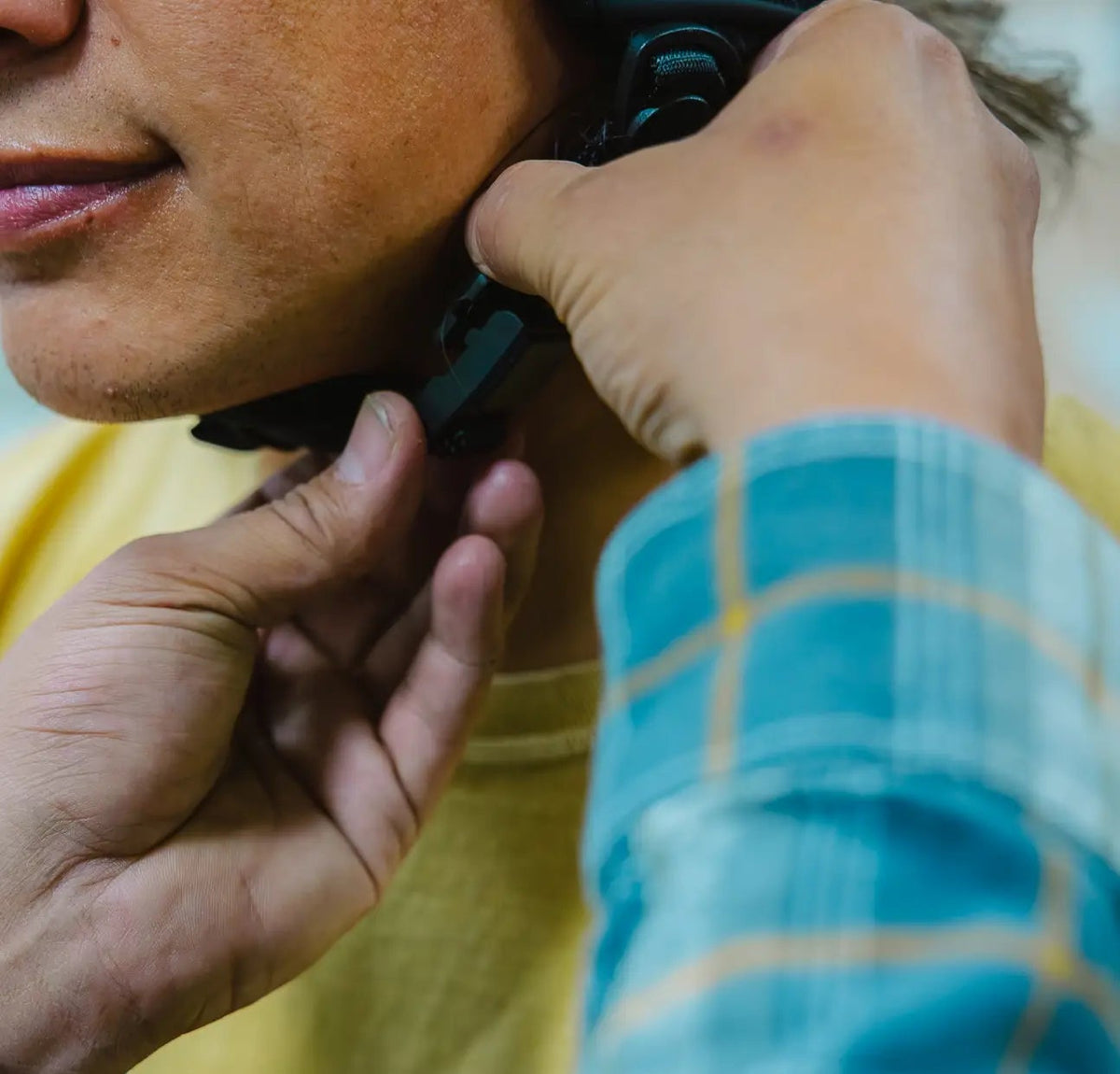 Person adjusting a ski helmet buckle on another person 